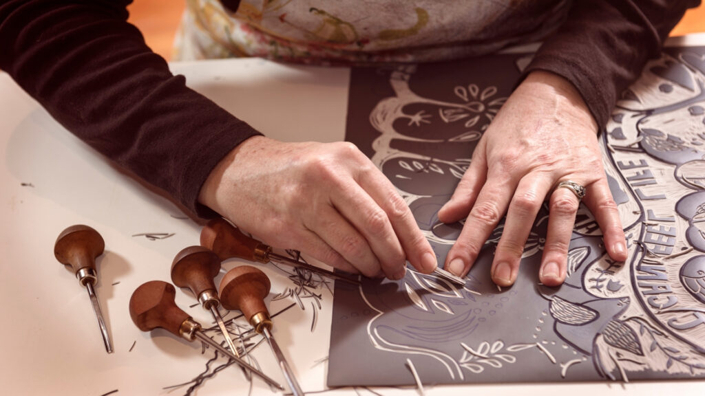 Création d'une gravure, gros plan sur deux mains.