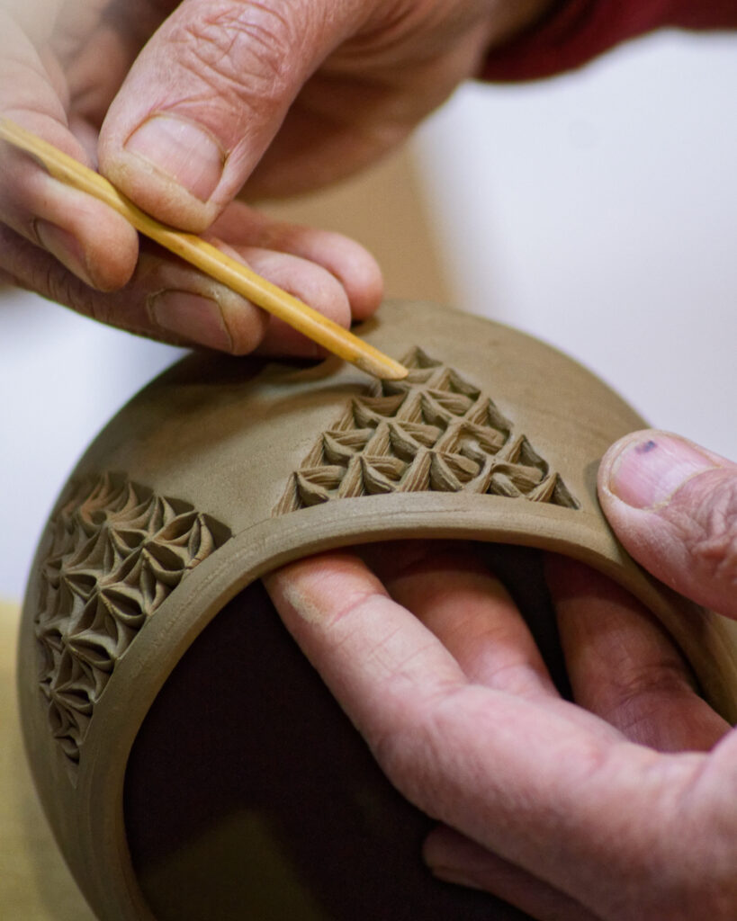 Objet en céramique dans une main.